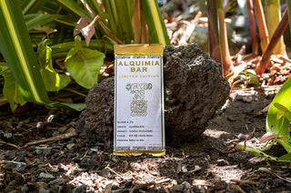 Alquimia Bar packaging on a rock with plants in the background