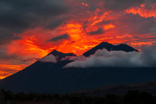 Sunset over mountains with fiery red and orange clouds